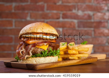 Home made hamburger with bacon and cheese on brick background