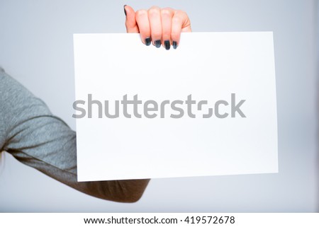 Pretty blond girl holding a blank sheet of paper to add your text