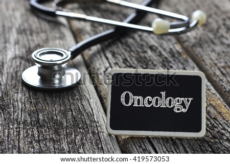 Medical Concept-Oncology word written on blackboard with Stethoscope on wood background Royalty-Free Stock Photo #419573053