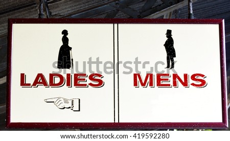 An old colonial Ladies and Mens restrooms sign.