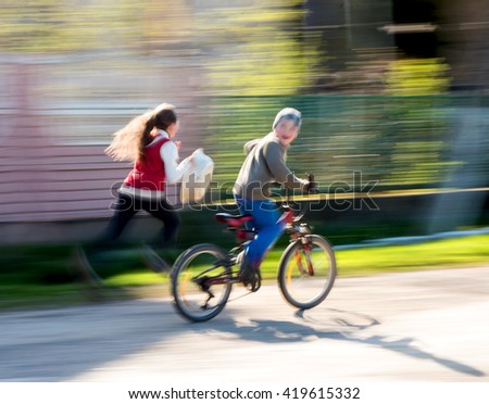 Children riding bicycles on a city street. Intentional motion blur
