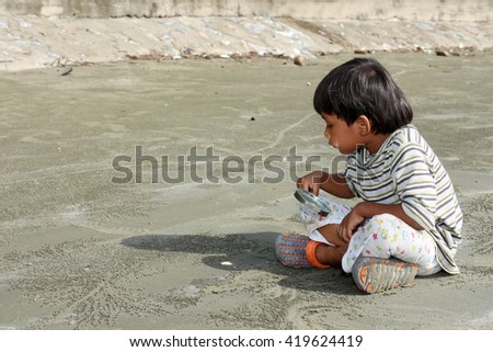 Joyful young boy examines a magnifying glass seashell on the beach summer sea
