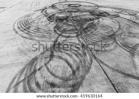 Abstract texture and background black tire tracks skid on asphalt road, Wheel tire tracks background, Car tire track skid mark on race track background, Above view, Automobile and automotive concept.