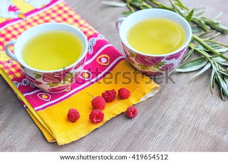 Beautiful tea cups and berries on wooden background
