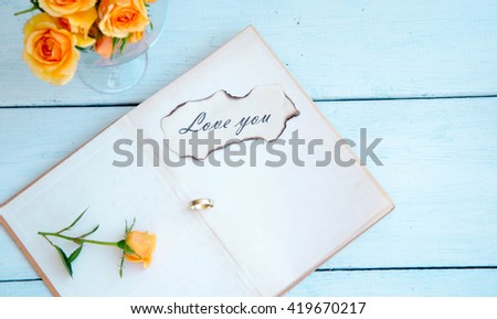 Blank notebook with flower on wooden table