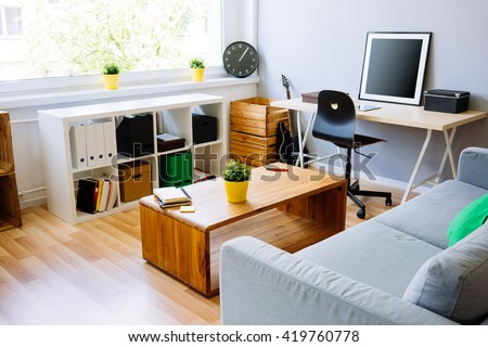Modern room, home office interior. Room with sofa, desk, chair, small table and other furniture Royalty-Free Stock Photo #419760778