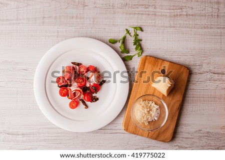 Salad with ham and tomatoes and cheese on a wooden table horizontal