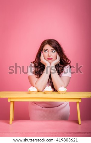 Close-up plump fat plus size redhead woman with long hair, curly with bright makeup and pink lips with sweet candy in hand handmade Vector pink background. Unusual emotion bored, sad