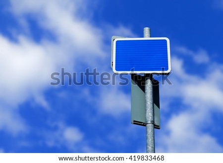 Blank blue customizable roadside signpost and blue summer sky.