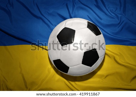  vintage black and white football ball on the national flag of ukraine