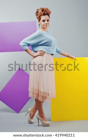 Full length studio portrait of young girl near art colored blanks. 