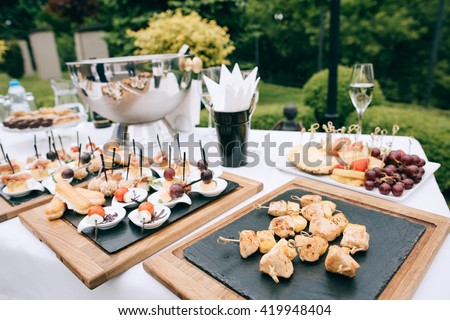 catering services in restaurant. Wedding table reception on wedding ceremony in the park Royalty-Free Stock Photo #419948404