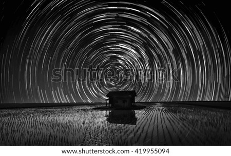 Star trail over abandoned wooden house in the middle of paddy field. ( Visible noise due to high ISO, soft focus, shallow DOF, slight motion blur)