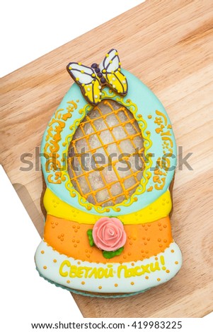 Colourful easter cake on a wooden board. Isolated on the white background. The Russian inscription is translated Happy Easter.