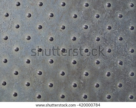 Old dotted iron checker plate. Worn metal texture background.