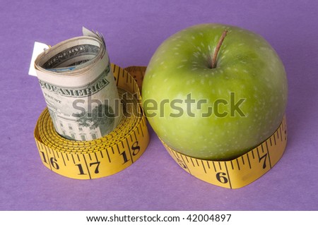 An apple, tape measure, and American currency represents the concept of measuring the cost of healthcare, food, or education.  Can also work for concept of the cost of healthcare, education or food.