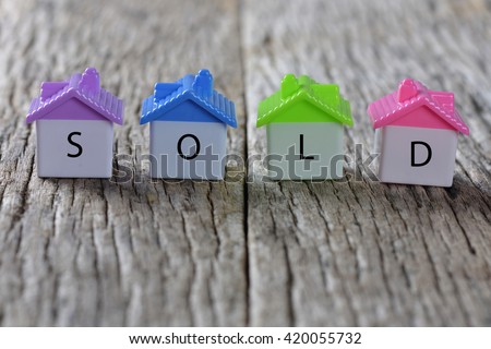 SOLD word on home icon with wooden background Royalty-Free Stock Photo #420055732