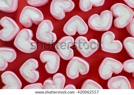 Pink heart marshmallows flat lay on red background