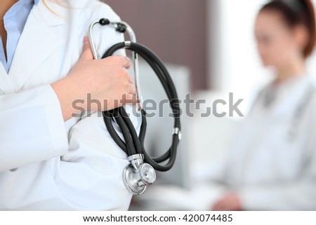 Female doctor standing in a hospital with her colleague in the background