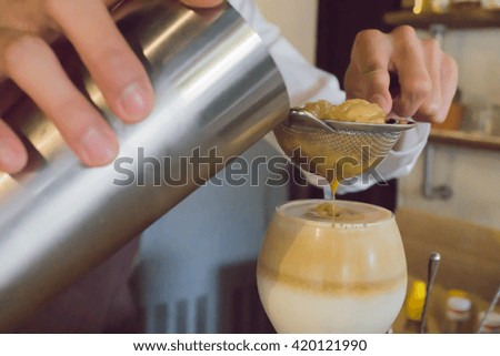barista is filtering ice from coffee
