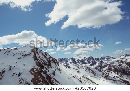 Alps - Wonderful view of snowy mountains and blue sky with clouds.