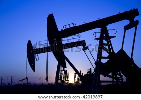 Silhouette of oil pump jacks with sunrise.