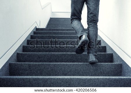 Colorized picture of one man walking upstairs on staircase indoors Royalty-Free Stock Photo #420206506