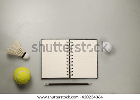 Golf ball, tennis ball, shuttlecock, notebook on white background, flat lay