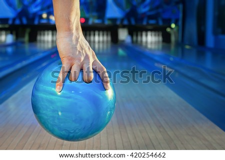a man's hand throws a bowling ball close-up, a man plays bowling on the background of the playing field