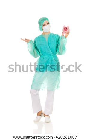 Female surgeon doctor holding piggy bank