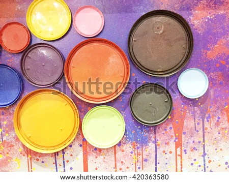 Extreme closeup colorful paint cans lid on a wall