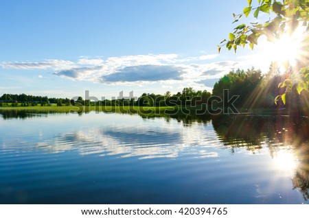 Shinny sun reflected in the lake, Finland. Royalty-Free Stock Photo #420394765
