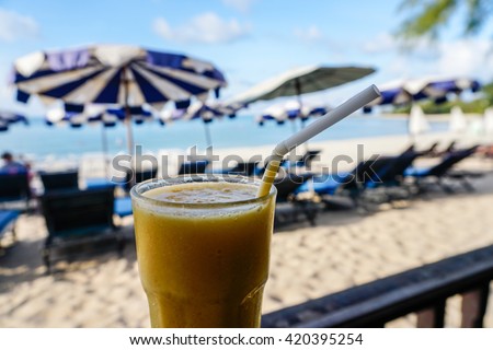 Glass of mango shake with sea view