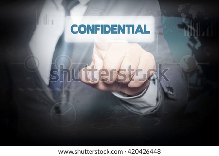 Businessman pressing button on touch screen interface and select CONFIDENTIAL. Business concept