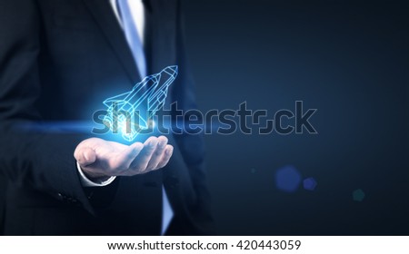 Start up concept with businessman holding abstract digital rocket Royalty-Free Stock Photo #420443059