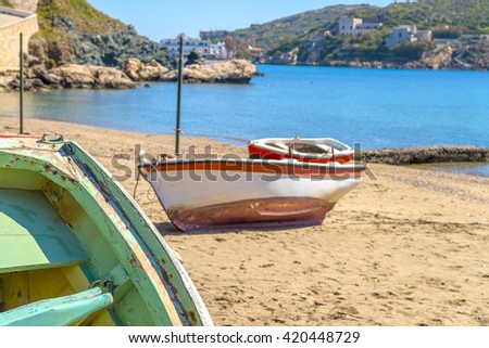 Traditional fishing boat on the shore during a sunny summer day. Calm blue sea in the background.