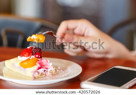 mix fruits crape with fork in hand