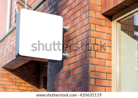 Blank mock up of shop street sign poster on a red brick wall