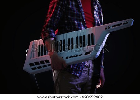 Male hands with synthesizer on dark background