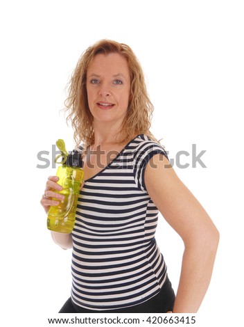 A blond woman standing in profile with her water
bottle in her hand, isolated for white background.
