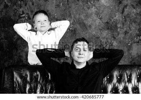 Portrait of dad and son in the same poses in black and white Royalty-Free Stock Photo #420685777