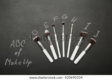 Set of make up brushes on black background with chalk pictures. ABC of make up concept.