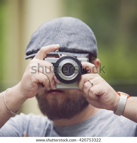 Young stylish photographer with vintage camera

