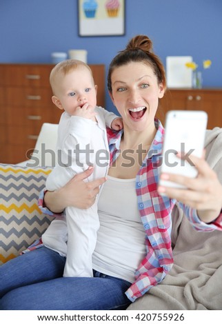 Young mother taking a selfie with her baby