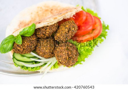 Falafel in pita bread and vegetables - Oriental cuisine. Tasty street food . Excellent choice for lunch and dinner. Close-up on a white background .
 Royalty-Free Stock Photo #420760543