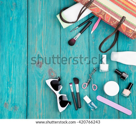 Travel concept - summer women set with straw bag, sunglasses, cosmetics makeup and essentials on blue wooden background Royalty-Free Stock Photo #420766243