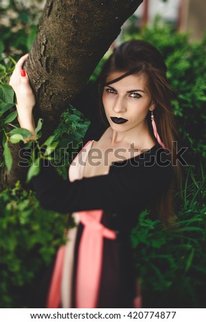 Alluring lady with black lipstick gazes piercing