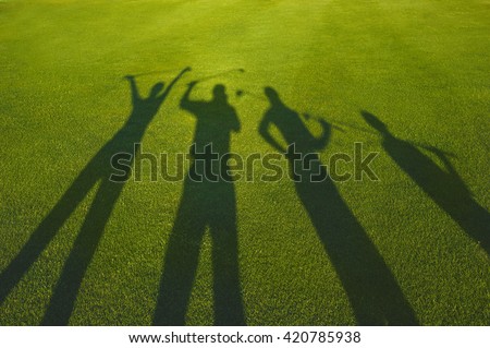 Four golfers with open hands silhouette on grass 