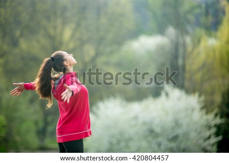 Profile portrait of happy sporty woman relaxing in park. Joyful female model breathing fresh air outdoors. Healthy active lifestyle concept. Copy space Royalty-Free Stock Photo #420804457