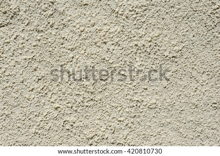 Beige roughly wall texture. Decorative plaster facade of the building.